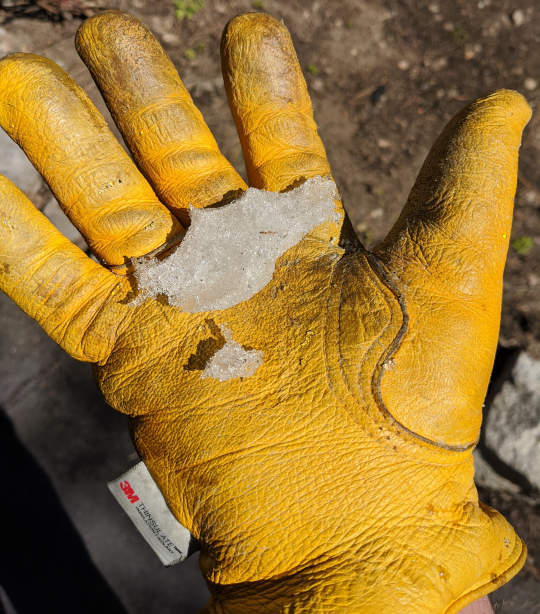 Yellow glove holding snow